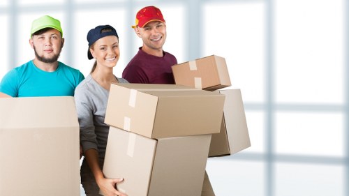 Professional movers transporting household items through a Stockwell street