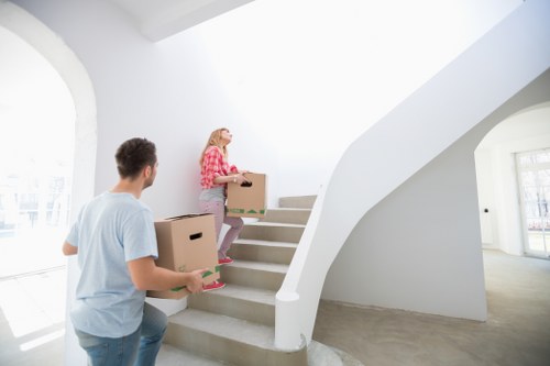 Movers loading boxed household items into a van for a Stockwell move